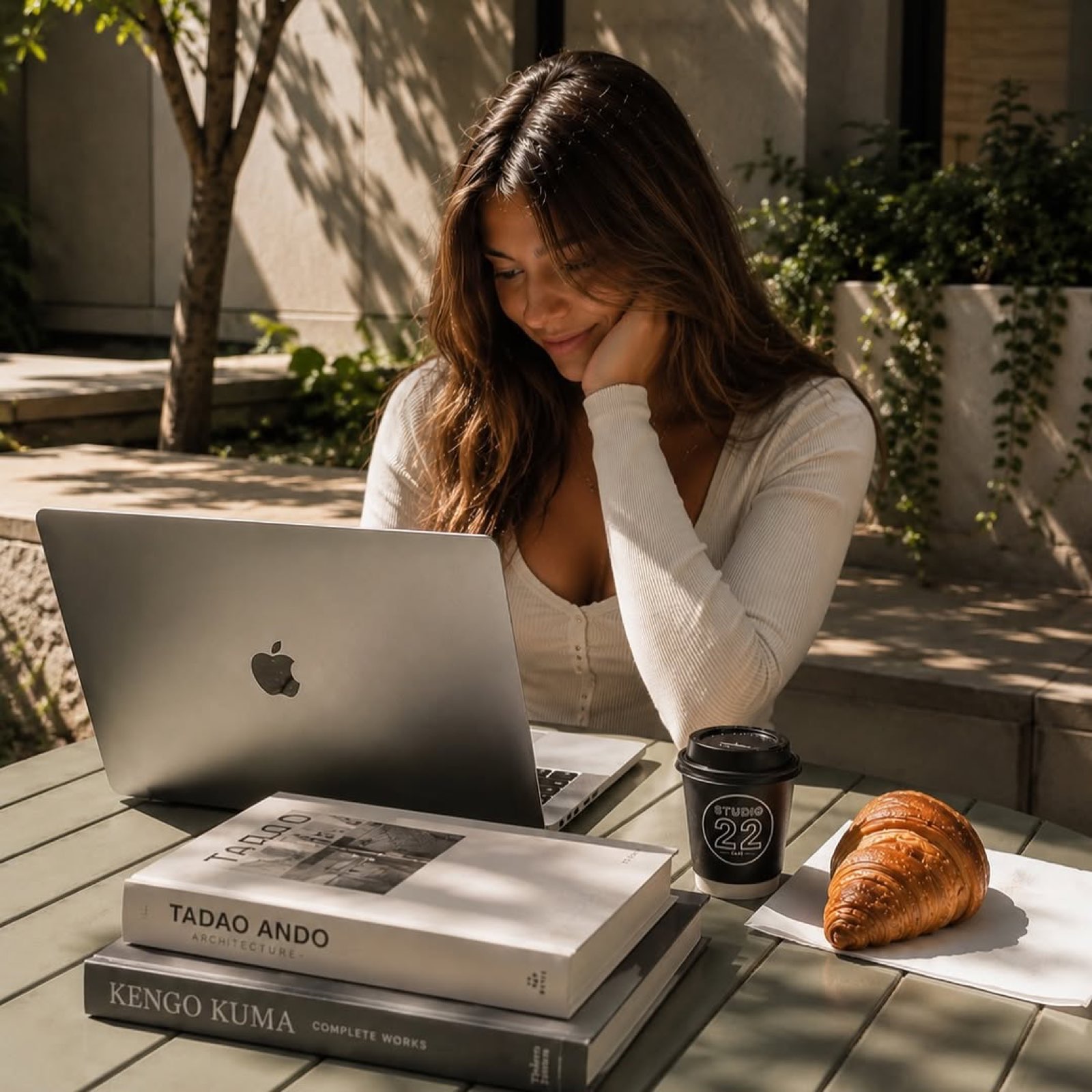 Studying with a Studio 22 coffee and croissant in the campus courtyard